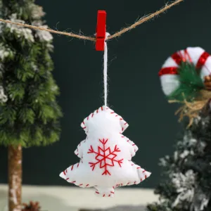 Christmas tree plush ornament detail, white felt hanging decoration with red stitched edges.