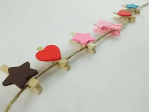Wooden decorative clips with colorful shapes on natural jute twine string for DIY photo wall.