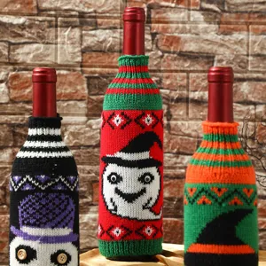 Halloween knitted wine bottle cover detail, festive ghost and witch pattern holiday table decor.