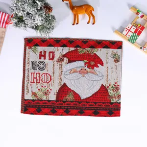 Detailed view of knitted Christmas placemat featuring Santa Claus and festive holiday text.