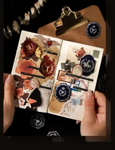 Macro view of vintage gilded emblem stickers applied to a dark phantom scrapbook