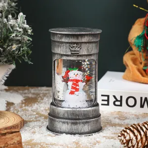 Kerst verlichte water sneeuwbol lantaarn met schattig sneeuwmannetje figuur, decor.