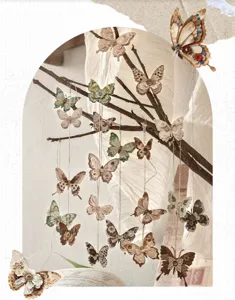 Primer plano de mariposas de papel vintage colgadas de ramas secas para decorar diarios.