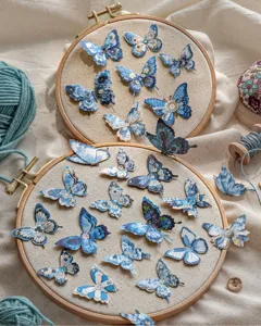 Vista detallada de pegatinas de mariposas azules vintage 3D en aros de bordar de madera