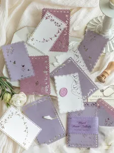 Dettaglio di carta pizzo viola con motivi di uccelli e farfalle per decorazione fai-da-te.