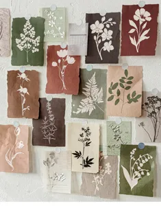 Detail view of botanical silhouette scrapbook paper with torn edges on a white wall