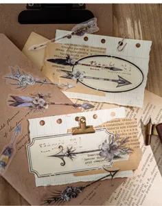 Detailopname van vintage veer- en pijlstickers op esthetische papierachtergrond.
