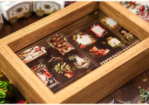 Vista detallada de las pegatinas festivas de scrapbooking en una caja de madera