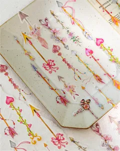 Gedetailleerde weergave van vintage aquarel stickers met pijlen en veren voor dagboek