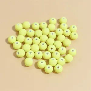Vista macro de cuentas redondas de arcilla polimérica amarillo pálido de 8 mm para artesanía