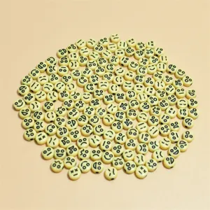 Detailansicht von 7mm cremefarbenen Acrylperlen mit schwarzen Emoji-Smiley-Mustern