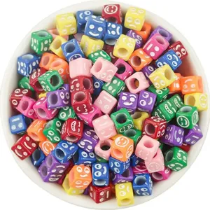 Close-up detail of colorful 6mm acrylic cube beads with various funny emoji faces.