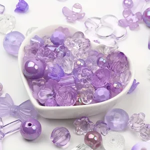 Close-up detail of mixed purple acrylic beads in various shapes for DIY jewelry making