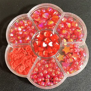 Vista detallada de cuentas rojas variadas para manualidades en caja con forma de flor