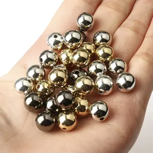 Détail de perles CCB dorées et argentées pour la fabrication de bijoux DIY sur la paume