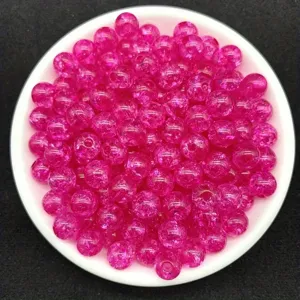 Close-up of 8mm magenta transparent crackle acrylic beads in a white dish