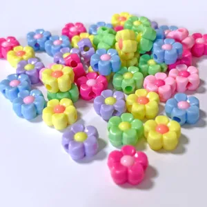 Primer plano de cuentas de acrílico en forma de flores para joyería hecha a mano.