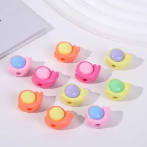 Vista macro de varias cuentas acrílicas de colores con forma de caracol para joyas DIY