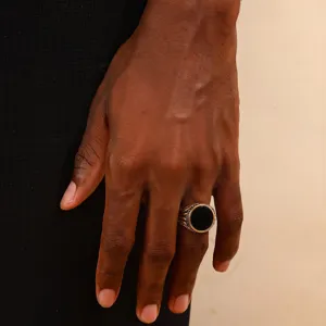 Detailed view of a men's vintage stainless steel ring with a black circular inlay.
