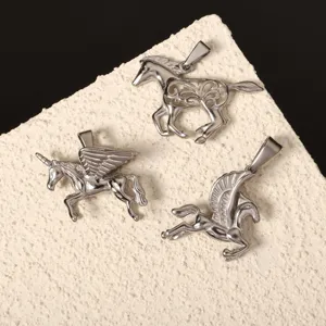 Dettaglio di tre ciondoli a forma di cavallo e Pegaso in acciaio inox per gioielli DIY.