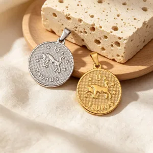 Nahaufnahme der Vintage-Stier-Tierkreisanhänger in Gold- und Silberoptik mit feiner Gravur.