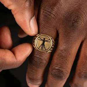 Vintage gold men's stainless steel signet ring with detailed Vitruvian Man relief