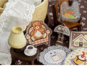 Detailed macro view of cozy pixel art bear and furniture stickers for DIY journaling decor