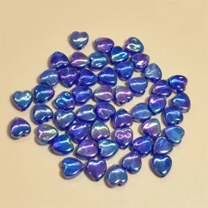 Detalle de cuentas acrílicas de corazón azul AB irisadas de 9 mm para creación de joyas DIY.