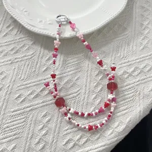 Vista detallada de cuentas de mariposa de acrílico rosa y rojo para manualidades de joyería