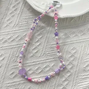 Detalle de cuentas acrílicas de colores con formas de flores y estrellas para móvil