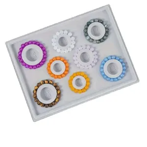 Tablero de diseño de cuentas gris con escalas de medida y pulseras de cuentas de colores
