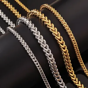 Detailed close-up of gold and silver stainless steel Franco chain necklaces for men.
