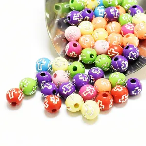 Gros plan de perles acryliques colorées de 8 mm avec croix d'argent pour créer des bijoux