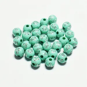 Vue détaillée de perles rondes en acrylique vert menthe 8mm avec motif de croix argent