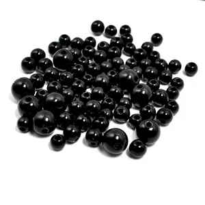 Primer plano de cuentas de acrílico redondas negras brillantes en varios tamaños para DIY.