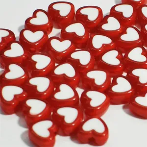 Primer plano de cuentas de corazón de acrílico rojo de 8 mm para creación de joyas DIY.