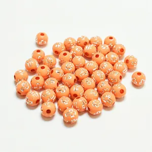 Perles rondes en acrylique orange de 8mm avec croix d'argent pour création de bijoux.