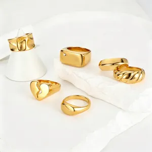 Detailed view of minimalist gold stainless steel rings collection on white stone