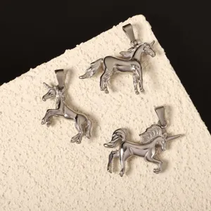 Makroansicht von drei Einhorn-Anhängern aus Edelstahl auf strukturierter Oberfläche