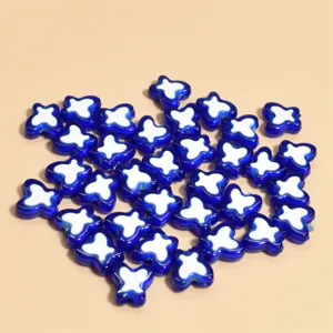 Detalle macro de cuentas de vidrio con forma de mariposa azul y blanca de 10mm para DIY