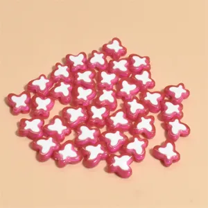 Vista detallada de cuentas de mariposa de 10 mm en rosa y blanco para crear joyas artesanales.