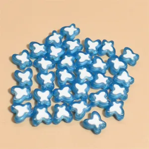 Detalle macro de cuentas de mariposa de acrílico azul y blanco 10mm para joyas de mano