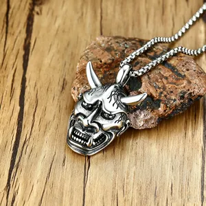 Macro view of vintage Hannya mask pendant necklace with intricate engraved demon face details