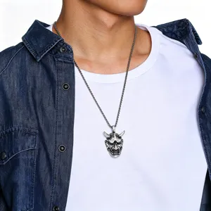 Detailed close-up view of a retro silver Hannya mask pendant necklace on a male model.