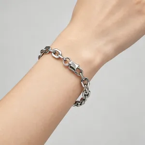 Macro view of a minimalist stainless steel paperclip chain bracelet worn on a wrist