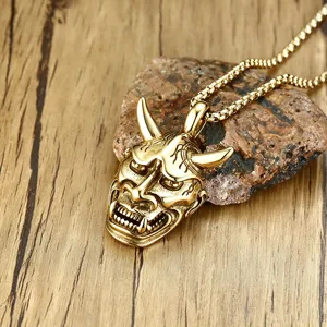 Macro view of vintage golden Hannya mask pendant with intricate carving details