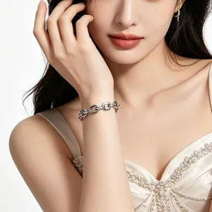 Detailed view of chunky stainless steel paperclip chain bracelet on woman's wrist.