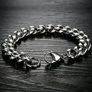 Detail shot of a heavy stainless steel Cuban link bracelet with a lobster clasp.