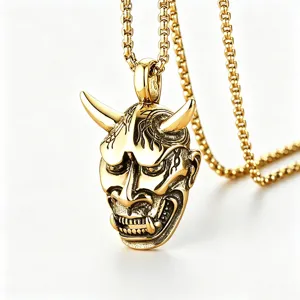 Macro view of vintage gold Hannya mask pendant necklace with intricate detailing and textures