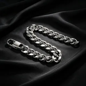Detailed macro view of a chunky silver stainless steel Cuban link bracelet on black silk background.